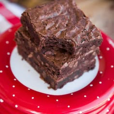 two pieces of brownie on a red and white plate