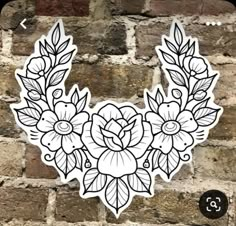 a white sticker with black and white flowers on it, against a brick wall