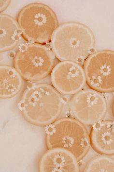 several slices of oranges with tiny white flowers on them are arranged in a pattern