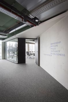 an empty conference room with glass walls and carpeted flooring is pictured in this image