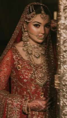 a woman in a red and gold wedding outfit