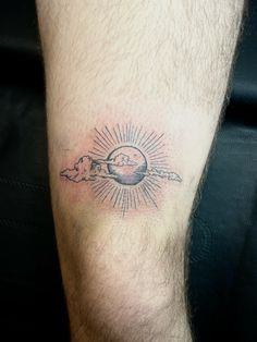 a man with a tattoo on his leg that has the sun and clouds in it