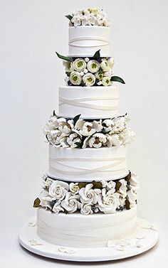 a three tiered cake with white flowers on top