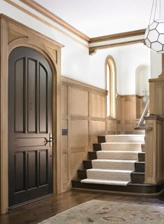 an entryway with stairs leading up to the door and light fixture on the wall