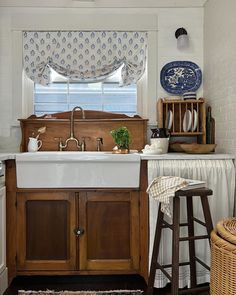 a kitchen with a sink, counter top and stools in front of the window