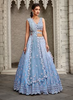 Editor's Note Ombre Dyed Ink Blue Organza Lehenga Set With A Belt With A Dainty Floral Embroidery Of Self And Contrasting Sequins, Beadwork, And Crystals Color: Blue Fabric: Organza Components: Lehenga, Blouse, Belt & Dupatta Care: Dry Clean Only About the Designer Nitika Gujral’s journey with designing clothes started almost four decades back while she was still in high school and held her first exhibition for family and friends. Making clothes has been a part of her life ever since. Traditional Lehenga Designs For Wedding, Lengha Ideas, Pretty Lehengas, Blue Organza Lehenga, Gown Photoshoot, Weddings 2024, Orang India, Saffron Spice, Designing Clothes