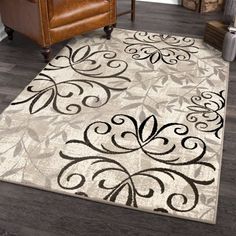 a white rug with black designs on it in a living room next to a brown chair