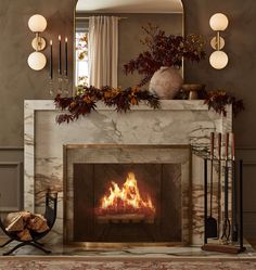 a fire place in a living room with a mirror above it and candles on the mantle