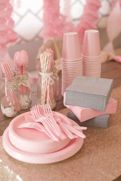 pink and gray table setting with plates, napkins, cups and utensils