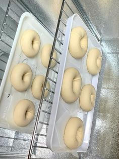 doughnuts are being made in an oven and placed on trays with cooling racks