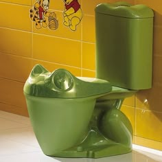 a green toilet sitting next to a yellow wall with winnie the pooh stickers on it