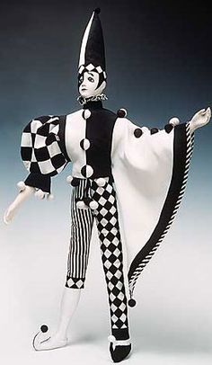 a figurine is dressed in black and white checkerboard clothing with a cape