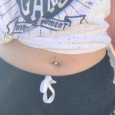 a woman's stomach with a tie around the waist and an arrow tattoo on it