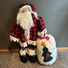 an old fashioned santa clause doll sitting next to a christmas sack and shoe bag on the floor