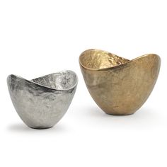 two metal bowls sitting next to each other