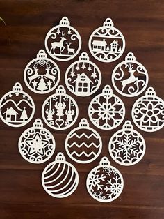 christmas ornaments cut out from paper on a wooden table with a plant in the background