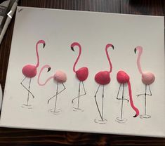 four pink flamingos are lined up on a white paper and one is in the shape of a ball