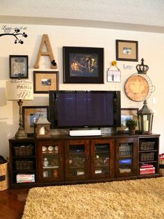 a flat screen tv sitting on top of a wooden entertainment center in a living room