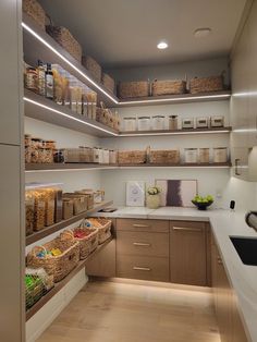 a kitchen with lots of shelves filled with food and baskets on top of the counters