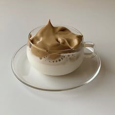 a bowl with some kind of food in it on a saucer next to a spoon