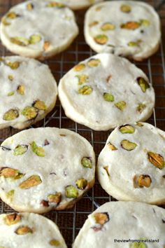 several cookies on a cooling rack with nuts and pistachios in the middle