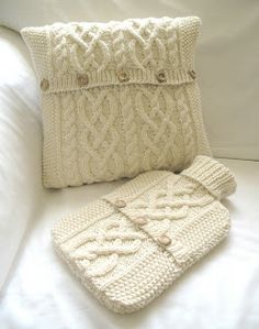 a white knitted pillow and case sitting on a bed next to it's cover