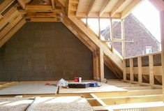 an unfinished attic with exposed rafters and wood flooring on the bottom half of it