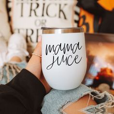 a woman holding up a coffee cup with the word mama juice on it