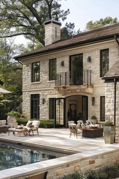 a house with a pool in front of it and an outdoor dining area next to it