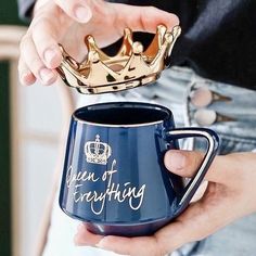 a person holding a coffee mug with a gold crown on it and the words queen of everything