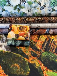 four different fabrics are stacked on top of each other in front of a floral wallpaper