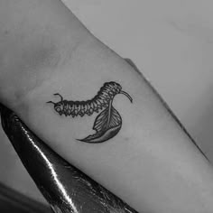 a black and white photo of a woman's arm with a butterfly tattoo on it