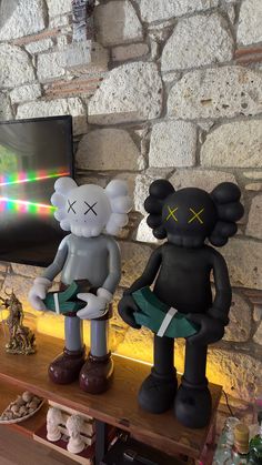 there are two statues that look like they have been placed on the shelf in front of the tv