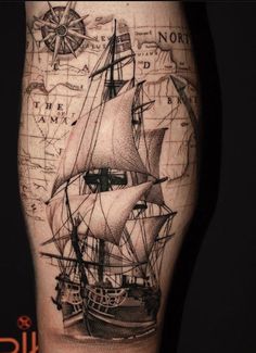 a man's leg with a ship on it and map in the back ground