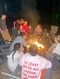 a group of people sitting around a fire pit