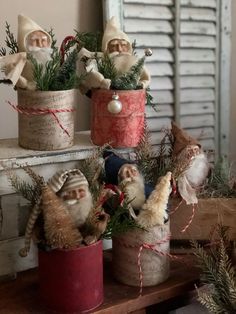 three tin canisters filled with gnome figurines sitting on top of a table