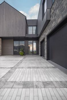 an empty courtyard with two garages and large windows