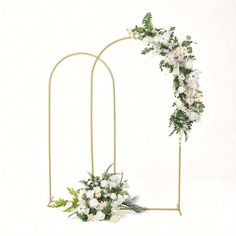 an arch decorated with white flowers and greenery