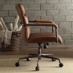 a brown office chair sitting on top of a wooden floor next to a brick wall