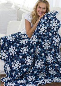 a woman is holding up a blanket with snowflakes on it