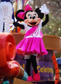 the minnie mouse mascot is waving at someone