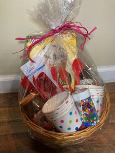 a basket filled with lots of food and condiments on top of a wooden floor