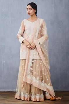 Peach short kurta with floral hand embroidered motifs. Paired with embroidered tulle sharara and embroidered tassel tulle dupatta.
Component: 3
Pattern: Embroidered
Type Of Work: Floral
Neckline: V Neck
Sleeve Type: Full Sleeves
Fabric: Kurta: Handwoven Chanderi, Sharara and Dupatta: Tulle
Color: Peach
Other Details: 
Hand embroidery
Tassel dupatta
Floral motifs
Occasion: Bride,Wedding - Aza Fashions Dori Embroidery, Butterfly Net, Peach Shorts, Short Kurta, Sharara Set, Net Fabric, Full Sleeves, Cotton Voile, Festival Wear