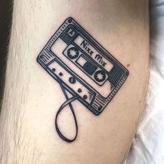 a black and white photo of a tattoo with an old school cassette tape on it