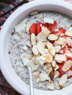 a bowl filled with oatmeal topped with sliced bananas and strawberries