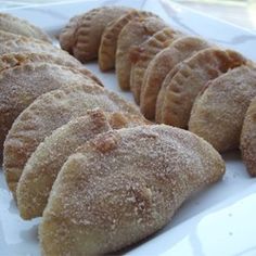 a white plate topped with cookies covered in powdered sugar