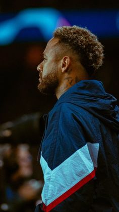 a close up of a person wearing a jacket and standing in front of a crowd