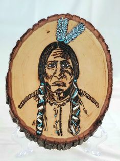 an image of a native american man on a tree slice with feathers in his hair