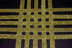 an abstract pattern made up of squares and lines in gold glitter on a black background