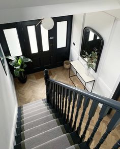 the stairs are made of wood and have gray carpeting on them, along with a black door that leads to another room